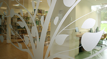 Blick durch eine Glastür in die Bibliothek