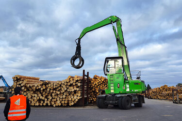 Studierende mit orangenen Warnwesten laufen über das Sägewerksgelände