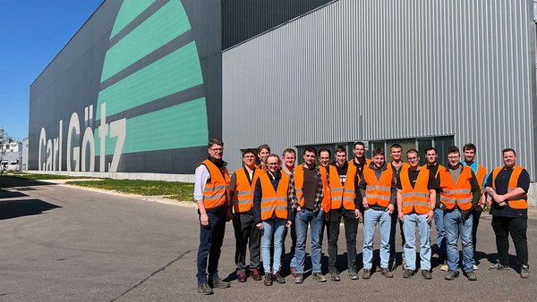 Gruppenfoto mit den Teilnehmern vor dem Firmengebäude.
