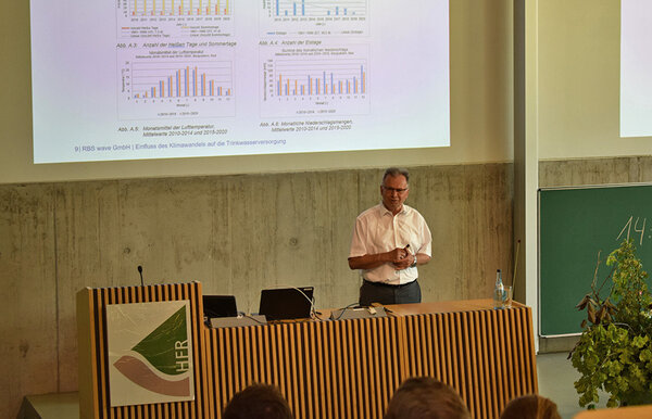 Dr.- Ing. Esad Osmancevic steht am Rednerpult in der Aula der Hochschule Rottenburg und hält einen Vortrag