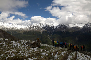 Studierende stehen als Gruppe im Gebirge mit Blick auf verschneite Berggipfel