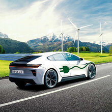 Ein E-Auto fährt auf einer Straße. Im Hintergrund stehen Windräder.