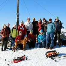 Gruppenfoto mit den Teilnehmern am Gipfelkreuz mit Schneeschuhen