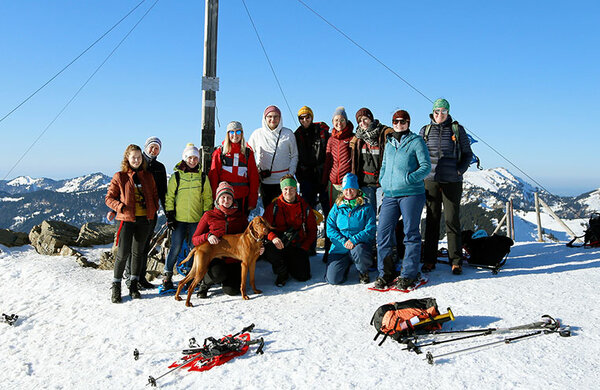 Gruppenfoto mit den Teilnehmern am Gipfelkreuz mit Schneeschuhen
