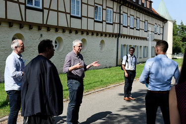Die Teilnehmer stehen mit Abstand vor dem Hauptgebäude der Hochschule Rottenburg und unterhalten sich