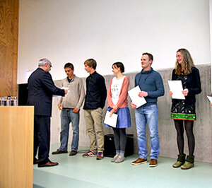 Studierende bekommen in der Aula das Deutschland-Stipendium überreicht