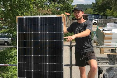 Student mit PV-Modul in der Hand