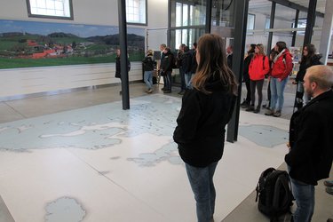 Studierende stehen in einem Informationszentrum