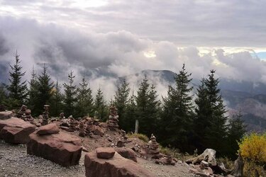 Aussichtspunkt mit Blick auf bewaldete Bergkuppen im Nebel