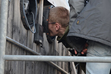 Ein Student schaut durch eine Luke in die Biogasanlage