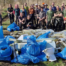 Gruppenfoto der Müllsammler. Im Vordergrund die große Menge an gesammelten Müll