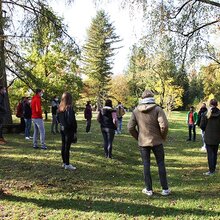 Studienanfänger stehen mit Abstand im Arboretum und hören den Studiengangkoordinatoren zu. 