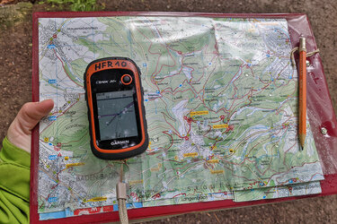 Ein GPS-Geräte für Wanderer liegt auf einer analogen Wanderkarte