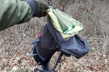 Weggeschmissener Rucksack mit Leergut in der Hand eines Sammlers