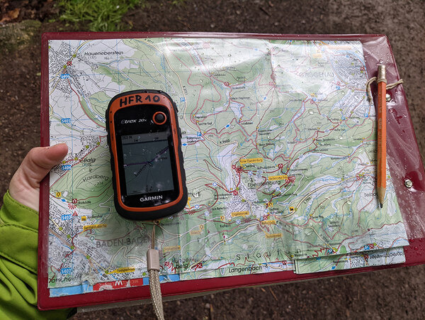 GPS-Gerät liegt auf einer analogen Wanderkarte