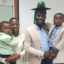 Gruppenfoto: Joseph Kusi mit Familie und Doktorhut (inkl. Modell einer Biogasanlage) nach erfolgreicher Verteidigung 