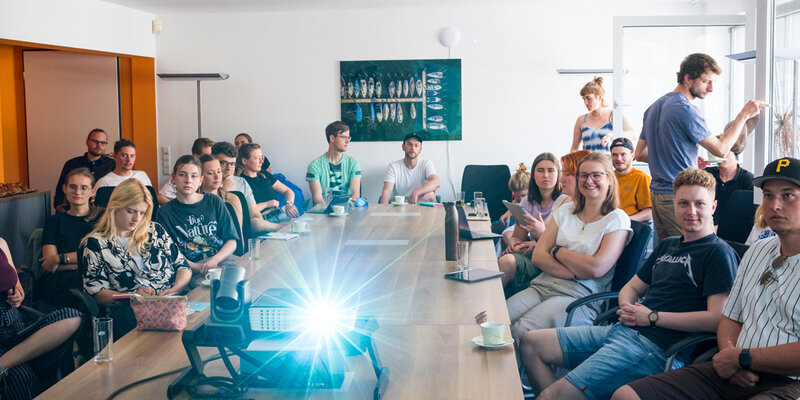 Studierende an einem langen Konferenztisch