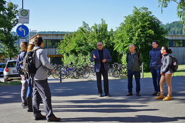 Die Teilnehmer stehen in einer Gruppe auf dem Campus der Hochschule für Forstwirtschaft Rottenburg. Der Rektor der Hochschule Prof. Bastian Kaiser referiert. 