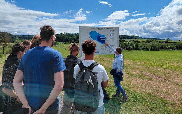 Prof. Bold erläutert den Studierenden das Hochwasserrückhaltebecken an einer Infotafel