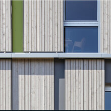 Ausschnitt einer Holzfassade eines Hauses mit Fenster