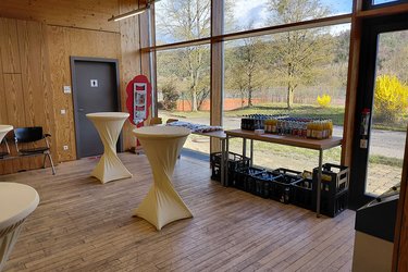 Blick auf die vorbereiteten Stehtische und Getränke im Vorraum der Aula