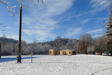 Blick auf die drei mobilen Module aus Holz im Winter bei Schnee