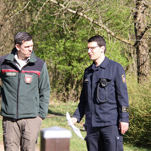 Ein Förster und ein Feuerwehrmann unterhalten sich im Wald