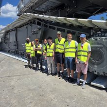 Gruppenfoto vor einem Kran auf dem Werksgelände