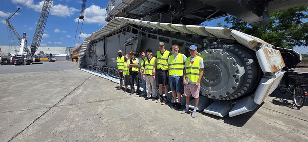 Gruppenfoto vor einem Kran auf dem Werksgelände
