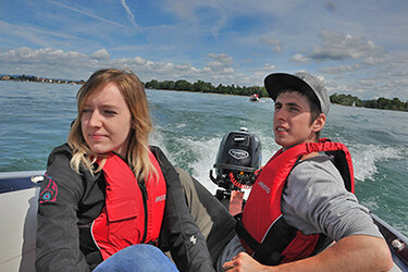 Zwei Studierende fahren mit dem Motorboot auf dem Bodensee