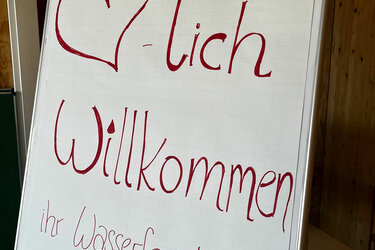 Flipchart mit der Aufschrift Herzlich willkommen ihr Wasserforschende