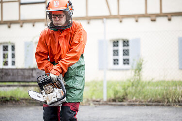 Studentin mit Motorsäge