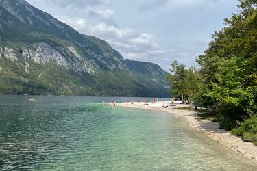 Blick auf einen Bergsee mit Badestrand