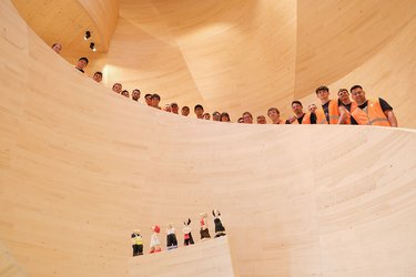 Gruppenfoto mit Studierenden in einem imposanten Holzgebäude