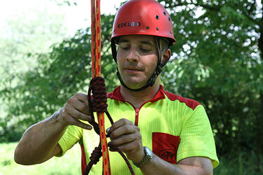 Wahlpflichtfach Seilklettertechnik A-Kurs - Baumkletterer mit Kletterausrüstung am Boden
