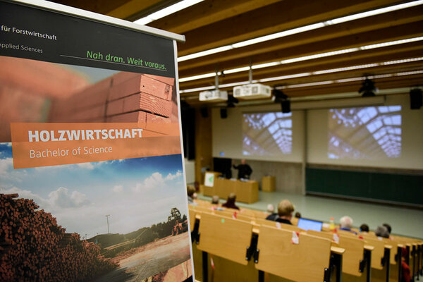 Plakat mit dem Titel "Bachelor Holzwirtschaft" steht in einem Hörsaal