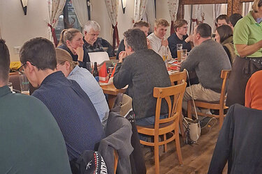 Teilnehmer der Feier sitzen an Tischen in der Gaststätte