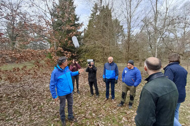 Prof. Ruge spricht mit den Gästen. Ein Filmteam zeichnet die Szene auf.