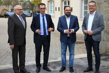 Gruppenfoto v.l.n.r.: Prof. Dr. Bastian Kaiser, Bundesminister Cem Özdemir, Chris Kühn MdB und Oberbürgermeister Stephan Neher vor dem Torbogen der Hochschule für Forstwirtschaft Rottenburg.