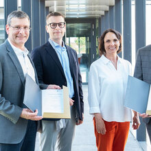 Gruppenfoto. Die Unterzeichner zeigen die Urkunde