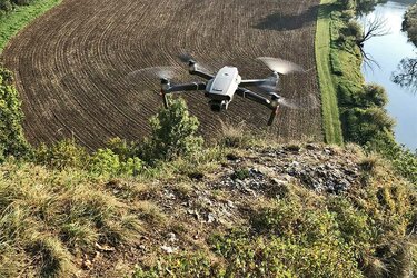 Fliegende Drohne über einem Flusstal