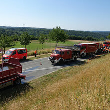 Blick auf mehrere Feuerwehrfahrzeuge auf einer Landstraße