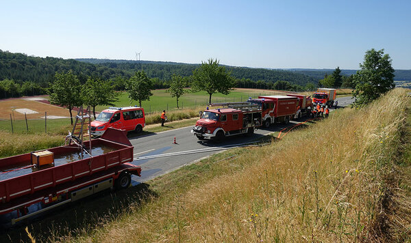 Blick auf mehrere Feuerwehrfahrzeuge auf einer Landstraße