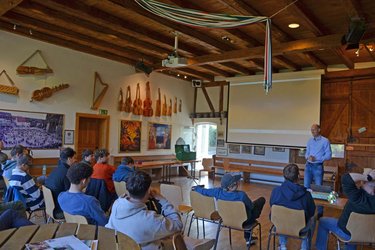 Studierende sitzen im Saal und hören dem Professor zu