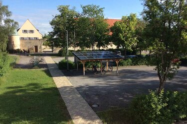 Blick auf das fertige PV-Carport. Im Hintergrund das Hauptgebäuder der Hochschule Rottenburg