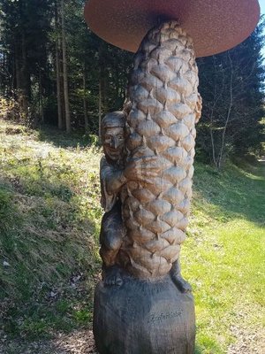 Skulptur aus Holz in Form eines Baumzapfen mit einem kleinen Männchen