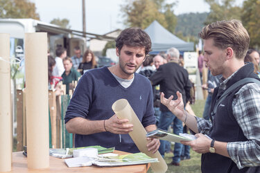 Teilnehmer im Beratungsgespräch am Infostand zu Wüchshüllen