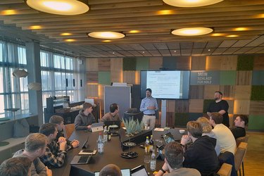 Studierende sitzen in einem Konferenzraum und präsentieren die Ergebnisse der Gruppenarbeit