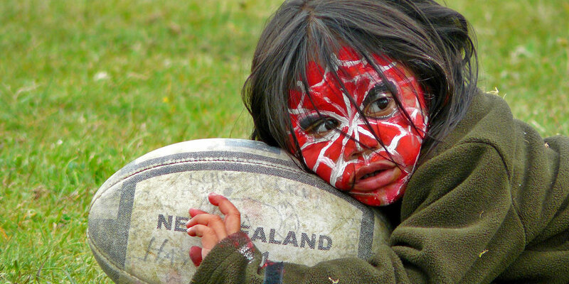 Kind mit Gesichtsbemalung und Rugbyball - Neuseeland