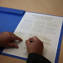 Hand, welche die gemeinsame Resolution gegen sexuelle Belästigung unterzeichnet